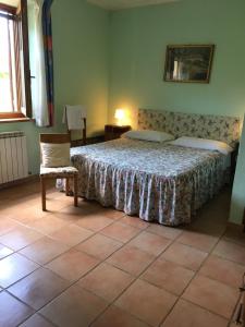 1 dormitorio con 1 cama y 1 silla en Il Bettarello, en Roccastrada