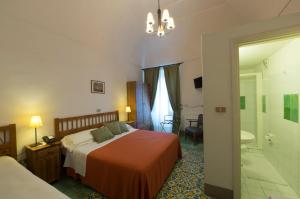 a hotel room with a bed and a bathroom at Hotel Parsifal - Antico Convento del 1288 in Ravello