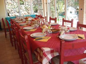 a table with a red table cloth and plates of food at Agriturismo Valdolivo in Cogoleto