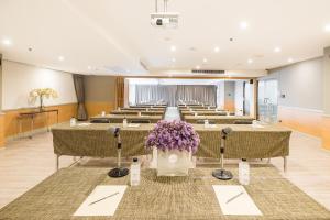 a room with rows of tables and purple flowers at Evergreen Place Siam by UHG in Bangkok +85 photos