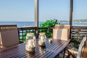 a wooden table with candles on a deck with the ocean at Asmini Villa in Pefki