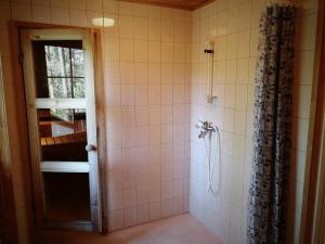 ein Badezimmer mit Dusche mit Glastür in der Unterkunft Tontti in Petääjärvi