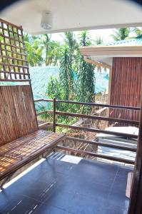 drewniana ławka siedząca na ganku obok płotu w obiekcie Sf Cantina w mieście Wyspa Bantayan