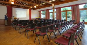 a lecture hall with chairs and a man giving a lecture at Mattenhof Resort in Interlaken