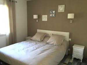 een bed met witte lakens en kussens in een slaapkamer bij Gîte de Roches Hibou in Seigy
