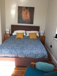 a bedroom with a bed with yellow pillows at The Flat Frank Lewis House in Hay-on-Wye