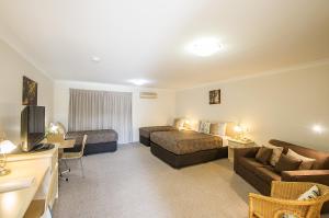 ein Hotelzimmer mit 2 Betten und einem Sofa in der Unterkunft Tuckerbox Motor Inn in Gundagai