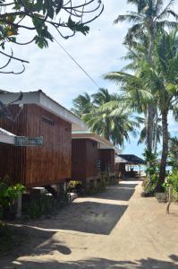 a row of houses on a beach with palm trees at Sf Cantina in Bantayan Island