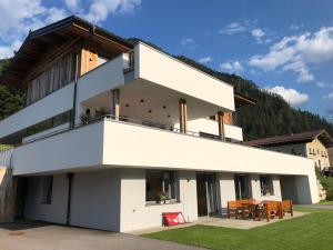 a white house with a table on the side of it at APART Forellenhof in Flachau