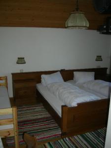 a bed in a room with a white wall at Gasthaus Kirchenwirt in Koppl