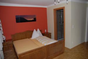 a couch in a room with an orange wall at Gasthaus Kirchenwirt in Koppl