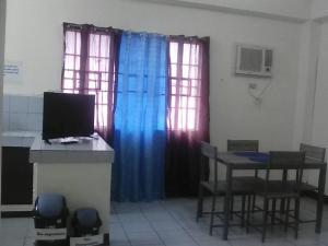 a room with a desk with a computer and two windows at JS3 Studio Apartments in Legazpi