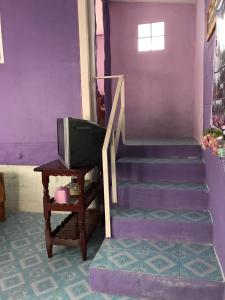 a purple staircase with a tv and a table at Panamma Hill Resort in Khao Kho