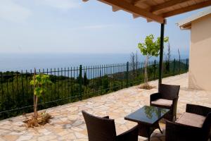 a patio with a table and chairs and a fence at Evi΄s Studios in Agios Nikitas