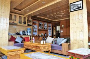 un soggiorno con divano viola e tavolo di Laksdup Guest House a Leh