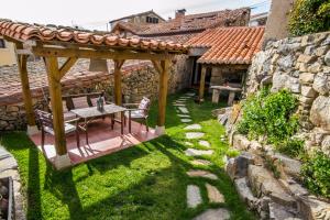 um gazebo de madeira com uma mesa num quintal em Casa rural La Rasa em Cabezas Altas