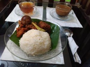 a plate of food with rice and meat on a table at Setro Kariyo Homestay in Bantul