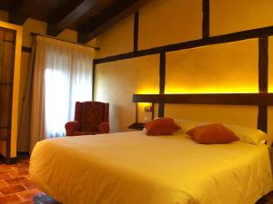 a bedroom with a large white bed and a chair at Font D'en Torres Solo Adultos in Morella