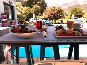 a table with a plate of food and a glass of wine at Aliston Hotel Thassos in Skala Potamias