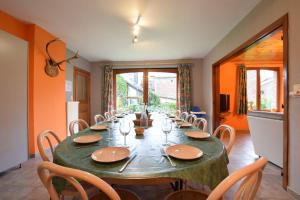 a dining room with a green table and chairs at La Méliraude in Daverdisse