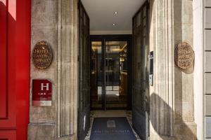 uma entrada para um edifício com uma porta vermelha em Hotel Antin Trinité em Paris