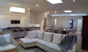 a living room with a white couch and a kitchen at Nuvola Loft in Zottegem