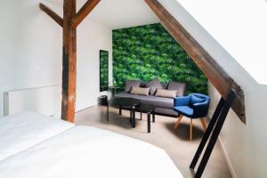 - une chambre avec un canapé et un fauteuil bleu dans l'établissement The People - Lille, à Lille