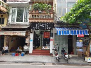 ハノイにあるHanu's Houseの正面にバイクを停めた路脇の店