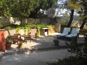 een groep stoelen en tafels in een tuin bij Apartman Tariba in Supetarska Draga