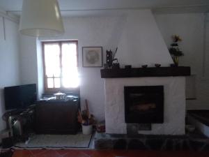 a living room with a fireplace and a window at Cà du Frà in Maissana