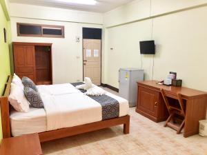 - une chambre avec un lit, un bureau et un ordinateur dans l'établissement Anchisa Mansion, à Phayao