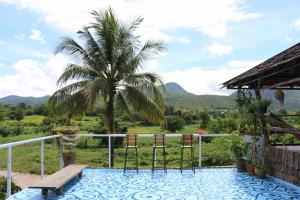 a balcony with a view of a palm tree and mountains at UP2U Guesthouse in Pai