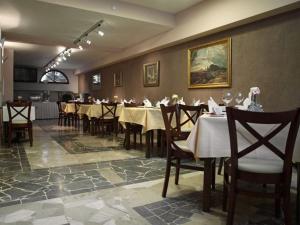 a restaurant with tables and chairs and a painting on the wall at Pensjonat M.F. in Elblag