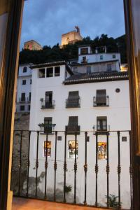 a view of a white building from a window at Hotel Rosa De oro in Granada