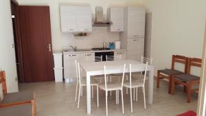 サンタレッシオ・シークロにあるResidence Lungomareの白いキッチン(白いテーブルと椅子付)