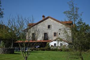 une grande maison blanche avec un toit rouge dans l'établissement Casona Camino de Hoz, à Anero