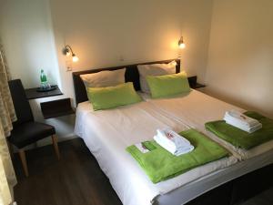 a bedroom with a bed with green towels on it at Hotel Tau-Lünne in Haselünne