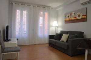 a living room with a couch and two windows at Apartamento Camino Laurel en Travesía Laurel Nº 6 in Logroño