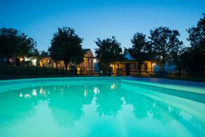 a swimming pool at night with a house in the background at Agriturismo Il Castellaro in Sassoferrato