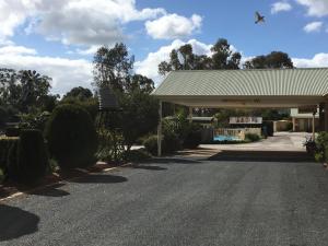 uma estrada em frente a um posto de gasolina com um edifício em Tuckerbox Motor Inn em Gundagai