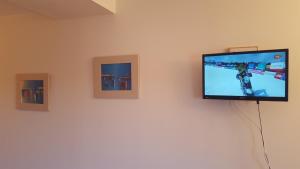 een flatscreen-tv aan de muur met drie foto's bij Posada Plaza Mayor de Alaejos in Alaejos