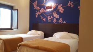 een kamer met twee bedden en een blauwe muur bij Posada Plaza Mayor de Alaejos in Alaejos