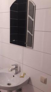 baño con lavabo y espejo en la pared en Hostel Vitan, en Leópolis