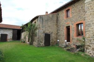 an old stone building with a green lawn in front of it at Gite de l'Elevage de la Mûre in Saint-Rambert-sur-Loire