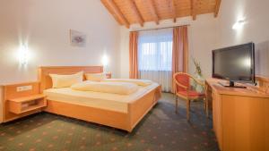 a bedroom with a bed and a desk and a television at Gasthaus Hotel Adler in Endingen