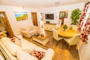 een woonkamer met een bank en een tafel bij Badgers Den - Covehurst Bay Holiday Cottage in Hastings