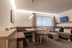 Televízia a/alebo spoločenská miestnosť v ubytovaní Apartments Tschanun