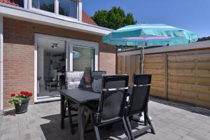 a table and chairs with an umbrella on a patio at IRISLAAN 9 in Oostkapelle