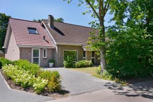 een huis met een rood dak en een oprit bij IRISLAAN 9 in Oostkapelle