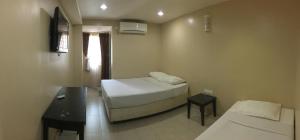 a small room with a bed and a desk and a bed sidx sidx sidx sidx at Pantai GuestHouse in Kuantan